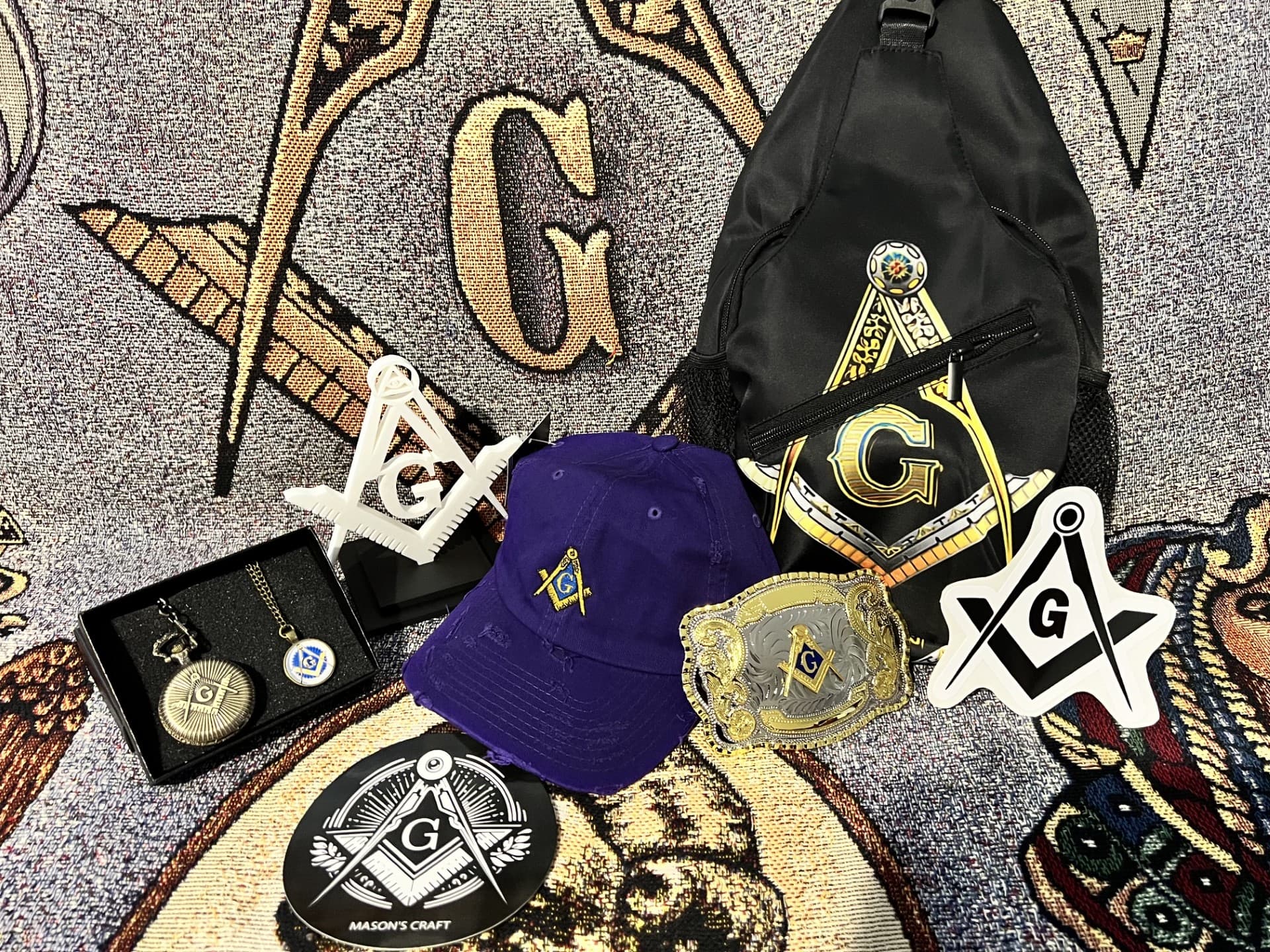 Close-up of the pocket watch, belt buckle, and Square & Compasses paperweight.